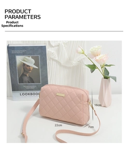 Close-up of pink quilted crossbody bag with golden metal logo and faux leather strap