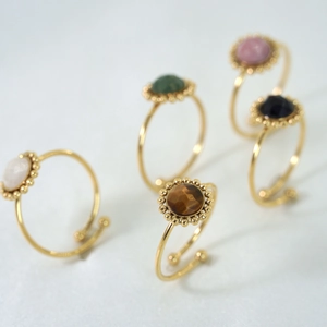 Detail of vintage gold rings with various colorful natural stones and beaded edges