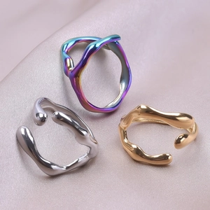 Detailed shot of irregular lava style open rings in silver, gold and iridescent finishes