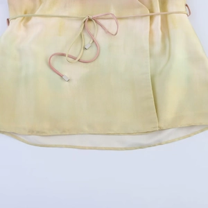 Détails du tissu en soie tie-dye jaune et vert avec embouts de cordon en métal et ourlet
