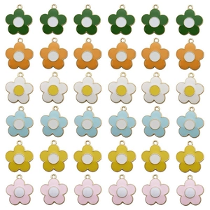 Top view of thirty-six colorful alloy flower charms with enamel finish on white background