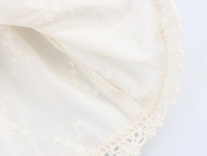 Gros plan sur le tissu jacquard blanc avec dentelle délicate et coutures surjetées