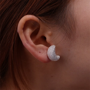 Close-up of silver crescent moon earrings featuring a textured frosted shimmer finish