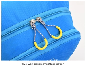 Detail of outdoor backpack featuring durable blue ripstop fabric and dual-way zippers