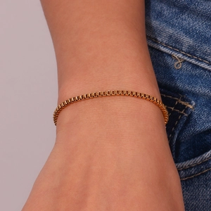 Close-up of minimalist 18K gold plated stainless steel box chain bracelet worn on wrist