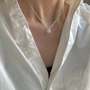 Detail of S925 sterling silver bird nest wire-wrapped freshwater pearl necklace on neck