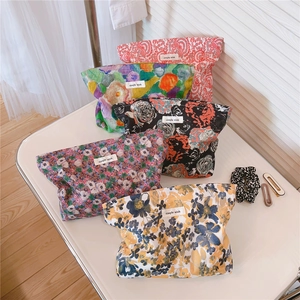 Macro view of five assorted vintage floral cotton cosmetic bags with brand labels