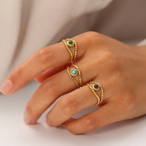 Close-up of three 18K gold-plated beaded rings set with malachite, turquoise, and lapis stones