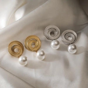 Elegant 18K gold and silver spiral earrings with round white pearls on silk