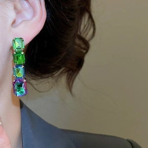 Detail shot of elegant long earrings with gradient rectangle gemstones on a model ear