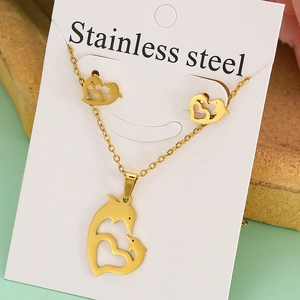 Detailed close-up of golden stainless steel jewelry set with dolphin and heart design
