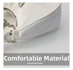 Detail of white crescent shoulder bag featuring silver metal chain and pleated texture