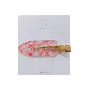 Pink marble acetate hair clip with gold metal base and floral patterns on white card