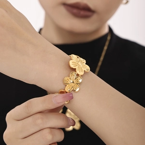Elegant gold-plated stainless steel floral bracelet worn on wrist for fashion look