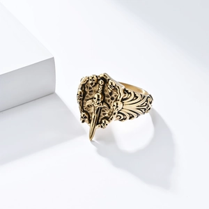 Detailed view of vintage gothic ring featuring skull, sword and shield in antique gold