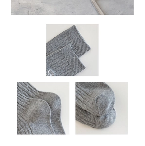 Détails de chaussettes en maille grise avec broderie lettre S et talon bien renforcé