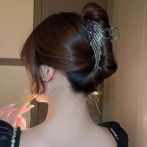 Elegant angel wing hair claw clip with purple rhinestones and opal on female model