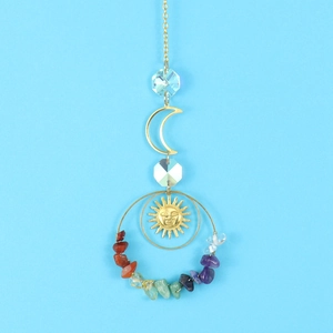 Detail of a golden crescent moon suncatcher with vibrant colorful raw crystal stones