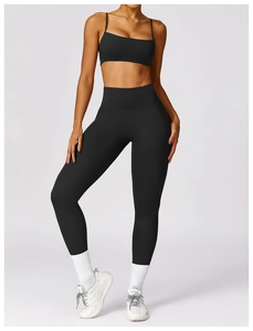 Detail eines schwarzen Yoga-Sets mit gekreuzten Trägern und schnelltrocknender Leggings