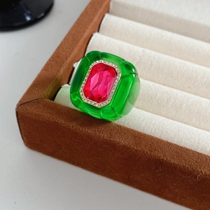 Détail d'une bague vintage en résine vert émeraude avec des cristaux rose vif