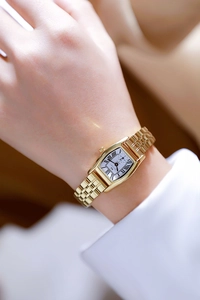 Close-up of elegant gold square watch with quartz movement on a female wrist