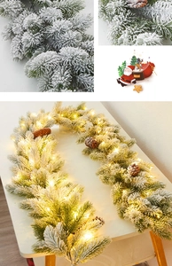 Détail de guirlande de Noël enneigée avec pommes de pin et lumières LED chaudes