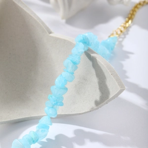 Close-up of bohemian light blue crushed stone bracelet with elegant gold chain links