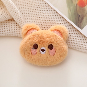 Close-up of cute plush bear pin accessory with soft texture and detailed embroidery