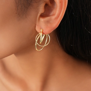 Detail view of a gold geometric multi-layered hollow circle earring on a model