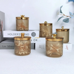 Luxurious transparent cotton swab holders with gold lids and elegant crown designs
