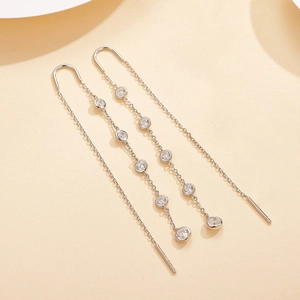 Detail of silver long tassel earrings with five clear round cubic zirconia in bezel setting