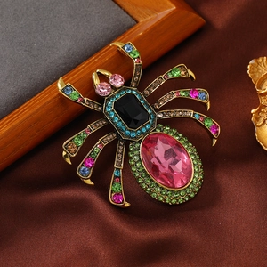 Vintage gold spider brooch with large pink oval crystal and colorful rhinestones