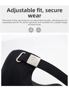 Detail of black cotton baseball cap showing adjustable matte silver metal buckle strap