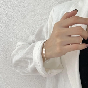 Minimalist S925 sterling silver chain bracelet with a pig nose charm worn by a model