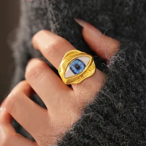 Vintage irregular golden open ring featuring a blue resin evil eye on a lava textured band