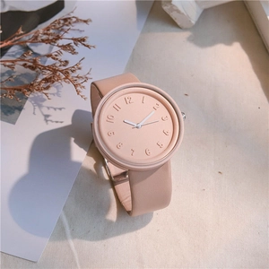 Detail of minimalist pink quartz watch with 3D dial numerals and leather strap