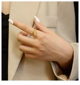 Detail of double-layered 18K gold-plated titanium ring with chain on model finger