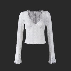 Close-up of intricate lace texture and flared sleeve detail on this white V-neck top