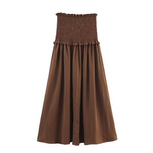 Detailed view of dark brown smocked elastic waistband and pleated fabric texture