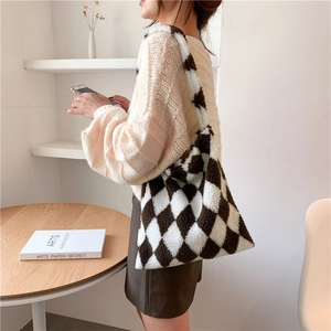 Close-up of plush shoulder bag featuring a classic black and white rhombic pattern