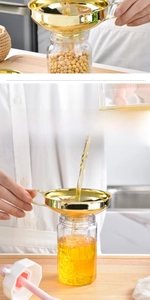 Detail of golden stainless steel funnel with wide mouth and round thickened handle