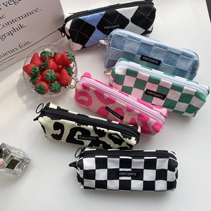 Close-up of six canvas stationery pouches in stylish checkered and animal prints