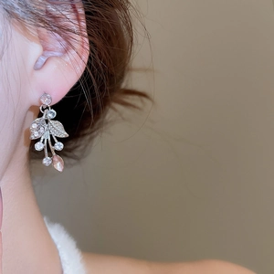 Detail of silver leaf earring with transparent crystals and pink teardrop gemstone