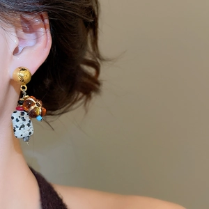 Detail view of vintage boho earrings with dalmatian stone and amber petals on model