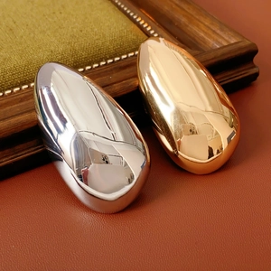 Detailed view of polished gold and silver irregular oval brooches on leather