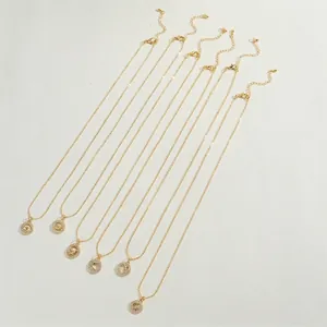 Set of gold necklaces with celestial star and moon pendants on a textured beige surface