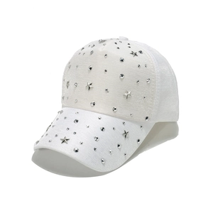 Detail of white baseball cap featuring silver star studs and rivets on the fabric