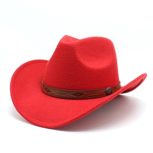 Detail of red cowboy hat featuring brown embossed band and metallic badge accent