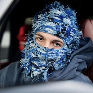Close-up of distressed knitted balaclava featuring blue dreadlock textures and eye cutouts