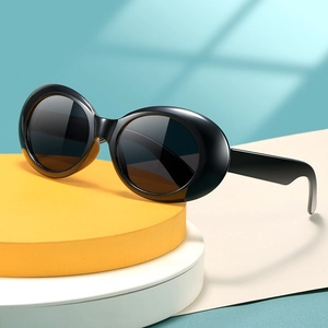 Vintage Kinder-Sonnenbrille mit schwarzem ovalem Rahmen auf modernen Displays für Kinder